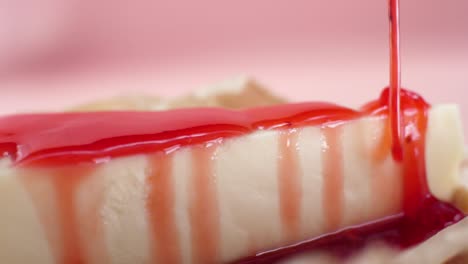 strawberry sauce pouring on cheesecake