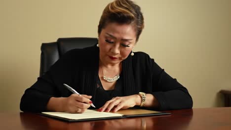 a professional woman engaged in signing documents with focus and intention in a stylish office setting, exemplifying concentration and elegance while marking important legal or business papers.