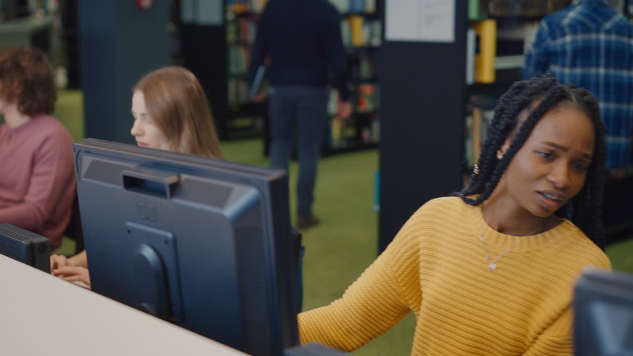 University Library: Row of Diverse Multi-Ethnic Group of Students Work on Computers, Learning, Studying for Exams, Writing Papers, do Research, Finish Class Assignments, Talk and Chat with Classmates