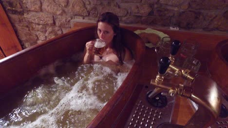 a woman in a beer spa toasts from a tub of boiling beer 2