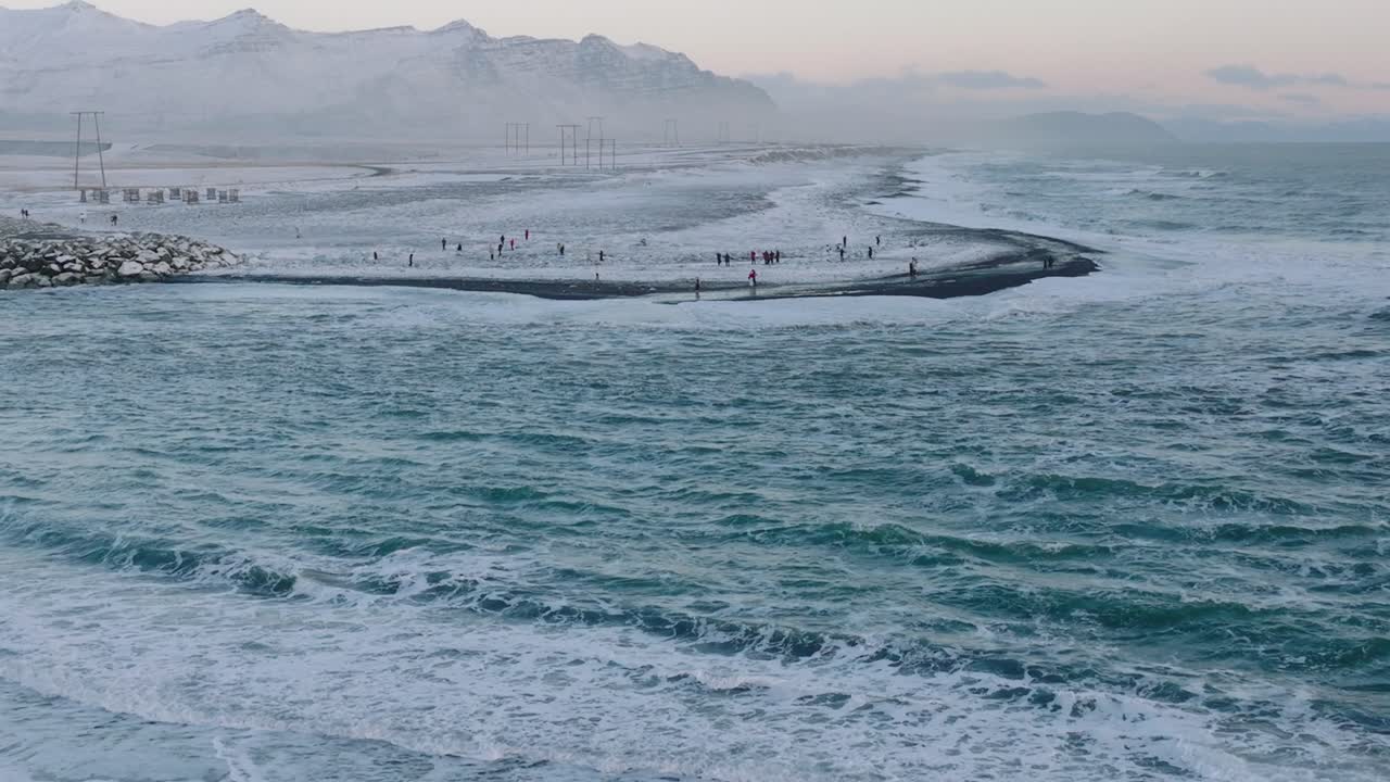 일몰 때 눈으로 뒤덮인 다이아몬드 해변 해안선에 있는 사람들의 공중 풍경