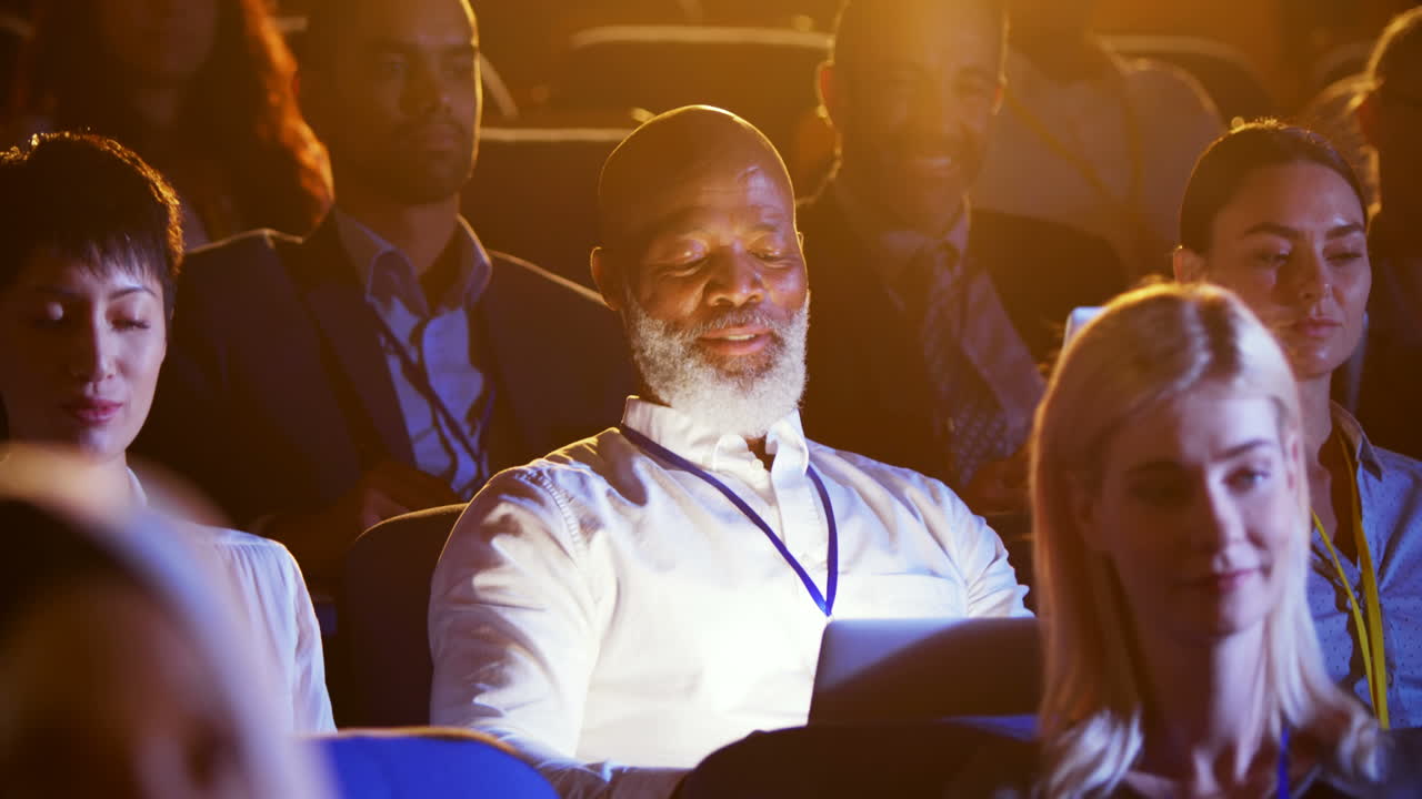 African American businessman using laptop during seminar in auditorium 4k