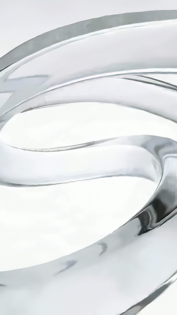 Vertical video: Rotating glass loops on light shift over white studio, revealing reflections