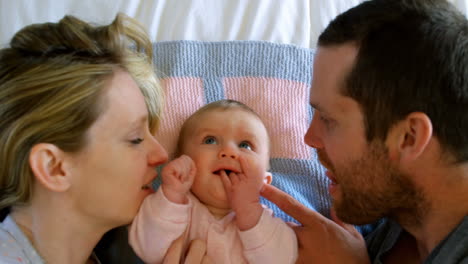 high angle view of happy caucasian parents having fun with baby on bed at home 4k