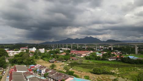 4K-Aerial-dolly-in-shot-of-high-speed-train-track-running-diagonally-across-the-frame-through-Muak-Lek-Mountains-in-a-developing-countryside-in-Thailand