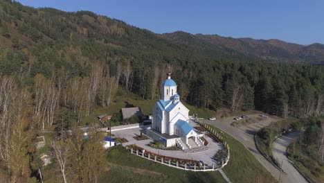 aerial view of a white church in a forest