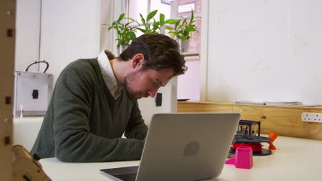 designer working beside a 3d printer in a design studio, shot on r3d