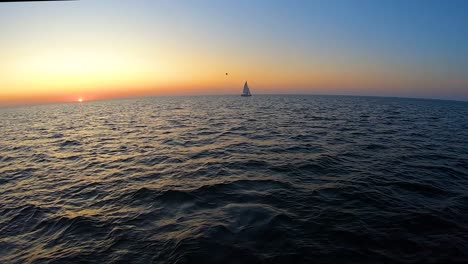 a yacht floats by the sea at sunset time lapse