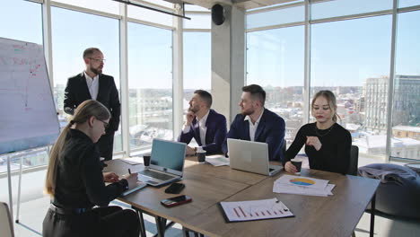 team meeting in the spacious office. business discussion and brainstorming with collegues. coworkers of both genders having a meeting in the office.