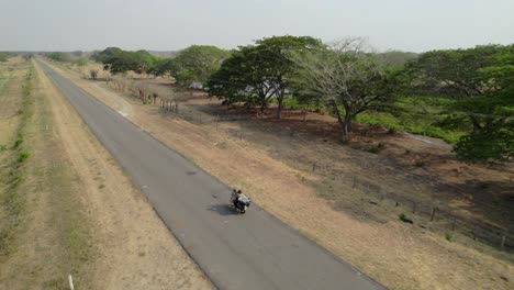 aerial follow of motorcyclist on rural road in guanarito, venezuela