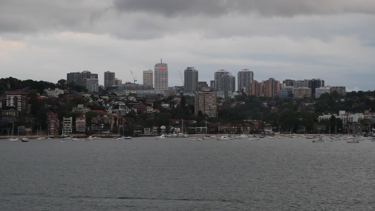 Small sailboats and yachts in Port Jackson, Sydney, Australia. Cloudy day.