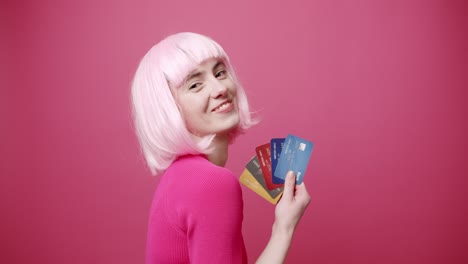 beauty woman with pink white hair and pink clothes. show in her hand credit card