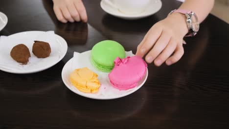 girl eating a pink macaroon