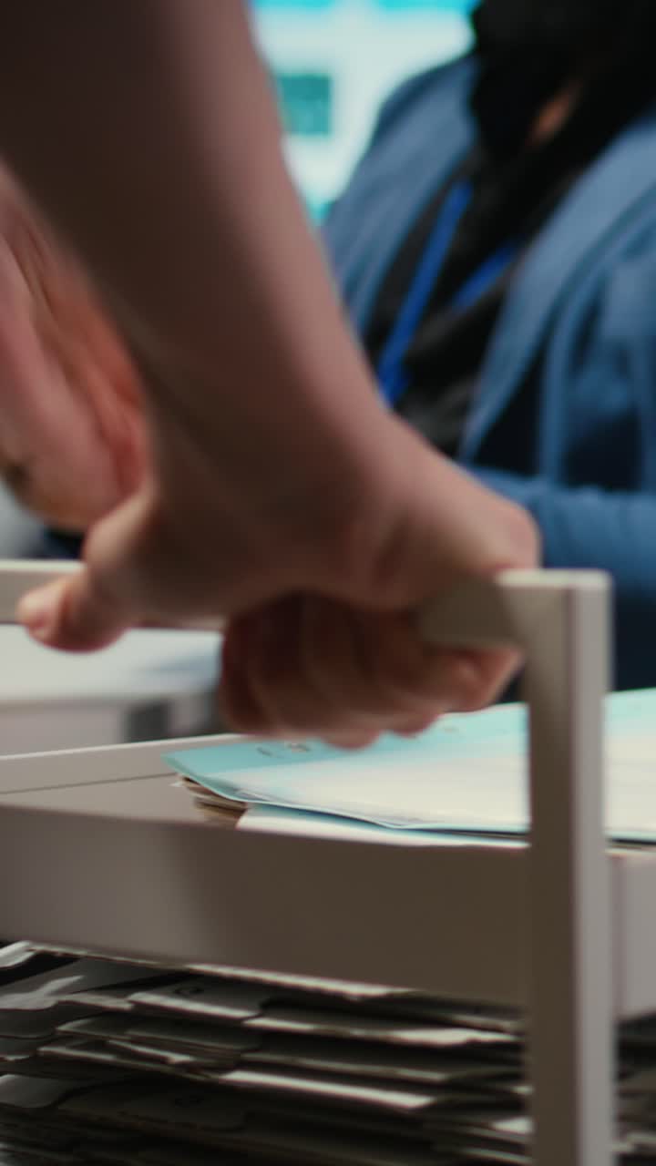 Vertical Video Professional archivist uses rolling trolley to transport documents