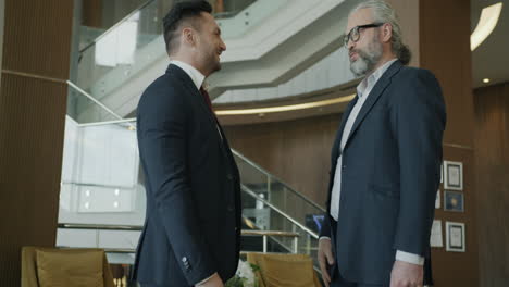 businessmen handshake in hotel lobby