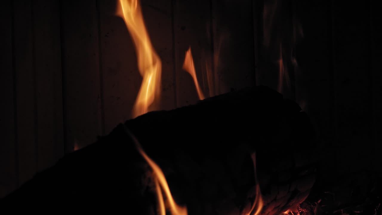 나무 통나무에 있는 벽난로에서 타는 불꽃