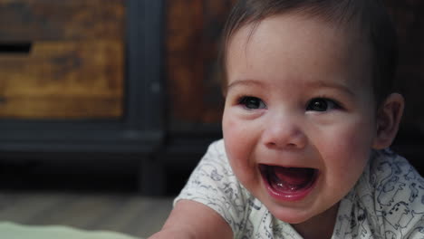 Baby-boy-smiling-on-the-ground-while-on-his-stomach-learning-how-to-crawl