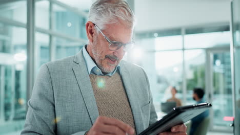 senior businessman reading on a tablet in an office
