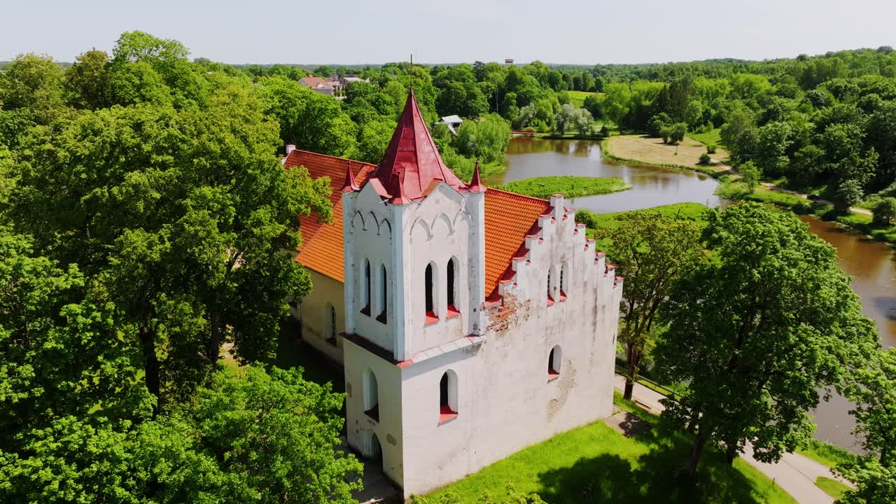 Cinematic Travel Concept Shows Historic Aizpute Latvia Church, Green Trees