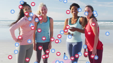 Animation-Von-Social-Media-Symbolen-über-Einer-Gruppe-Unterschiedlich-Fitter-Frauen,-Die-Gemeinsam-Am-Strand-Lächeln