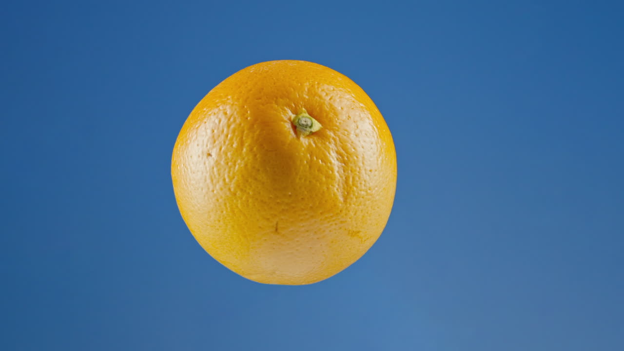 Arancia isolata che gira sullo sfondo di uno schermo blu per chroma key