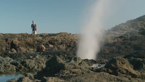 male traveler walking near blowhole