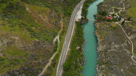 highway next to turquoise water river, bike track alongside road