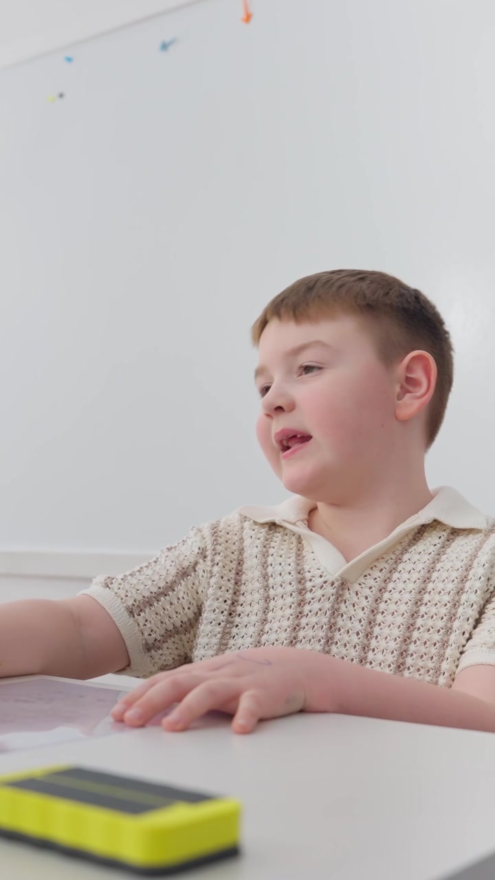 Ragazzo intento a imparare alla scrivania e mentre parla