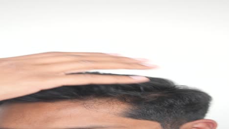 closeup of a man's head, hand touching his forehead