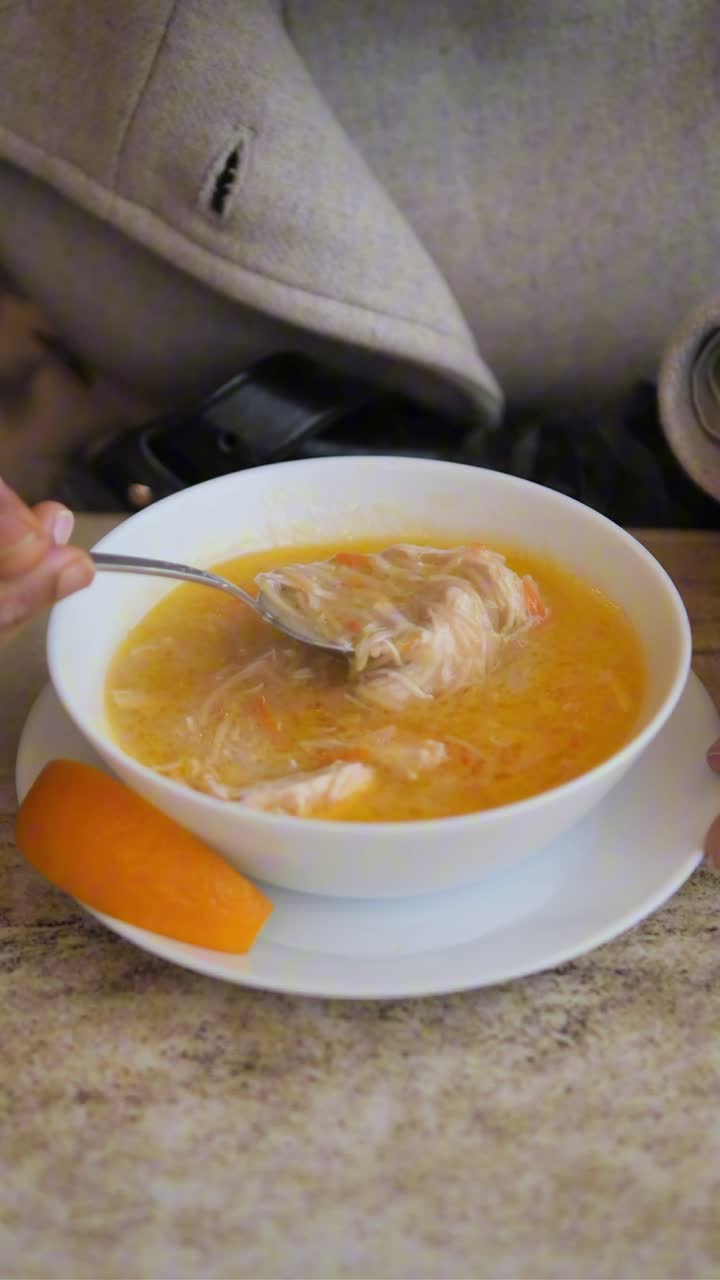 Nærbillede af person, der rører i og spiser varm suppe