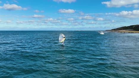 Aerial-Orbit-Shot-of-Person-Riding-Hydro-Foil-and-Wing-Surfing-on-Beautiful-Sunny-Day-on-the-Ocean