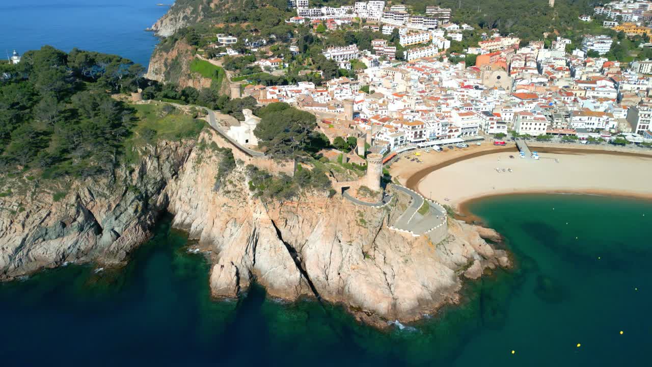 Pemandangan udara Tossa de Mar yang menakjubkan, sebuah kota pesisir menawan yang terletak di Costa Brava, Catalonia, Spanyol, menampilkan pantai indahnya, kastil bersejarah, dan bangunan bercat putih