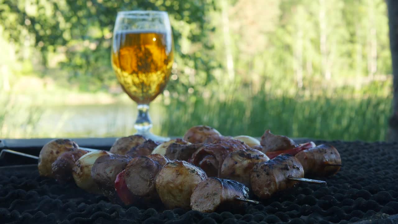 Carne e verdure mescolate insieme e infilzate su uno spiedino di metallo vengono grigliate su un barbecue a carbonella ardente