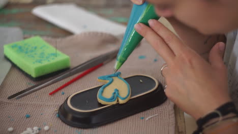 imágenes de una mujer caucásica haciendo y glaseando galletas de ballena