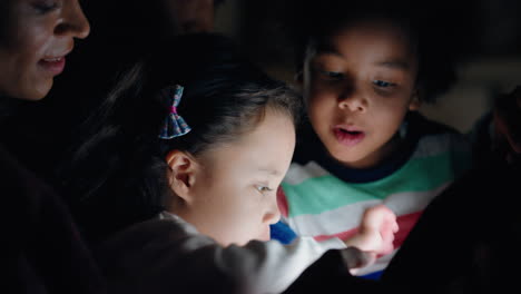 familia feliz usando una tableta con los niños madre y padre viendo a los niños jugar a juegos en la tecnología de pantalla táctil disfrutando de una noche relajante antes de acostarse