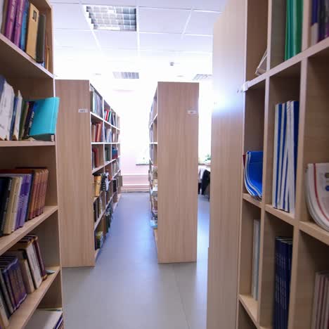 wooden bookcases in the library. different books on bookshelves inside the light library room. education and knowledge concept