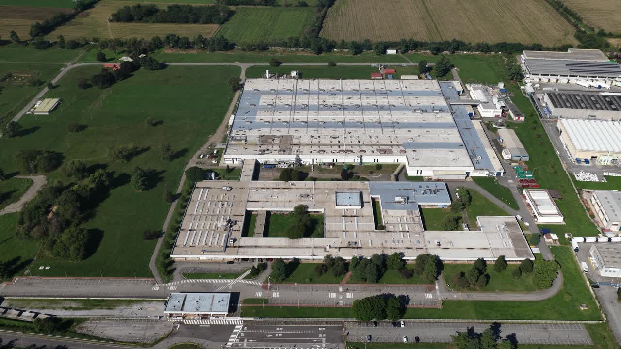Aziende industriali, imprese di assemblaggio ed edifici del settore produttivo nel Nord Italia. Attività industriale, produzione e contesto economico regionale. Video aereo realizzato con drone.