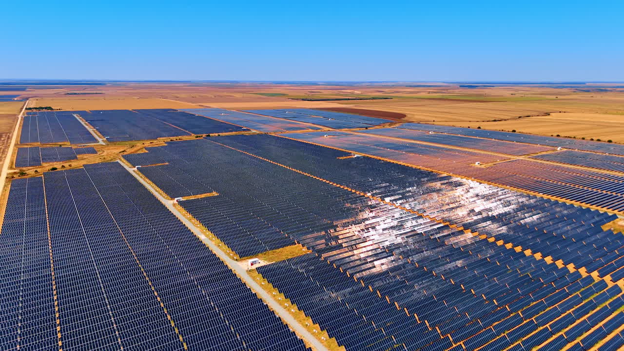 Solar energy field in clear blue skies. Vast solar panel array stretches across the landscape under bright blue skies, capturing sunlight for energy generation