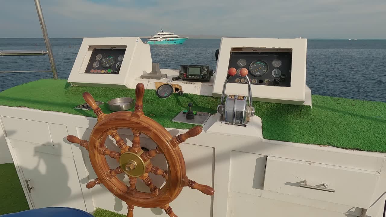 Steering Wheel and Navigation Compass on a Yacht Background of Red Sea