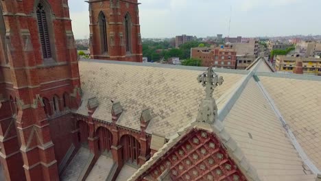 aerial view of a church top with city in the background , a black kite sit on the church