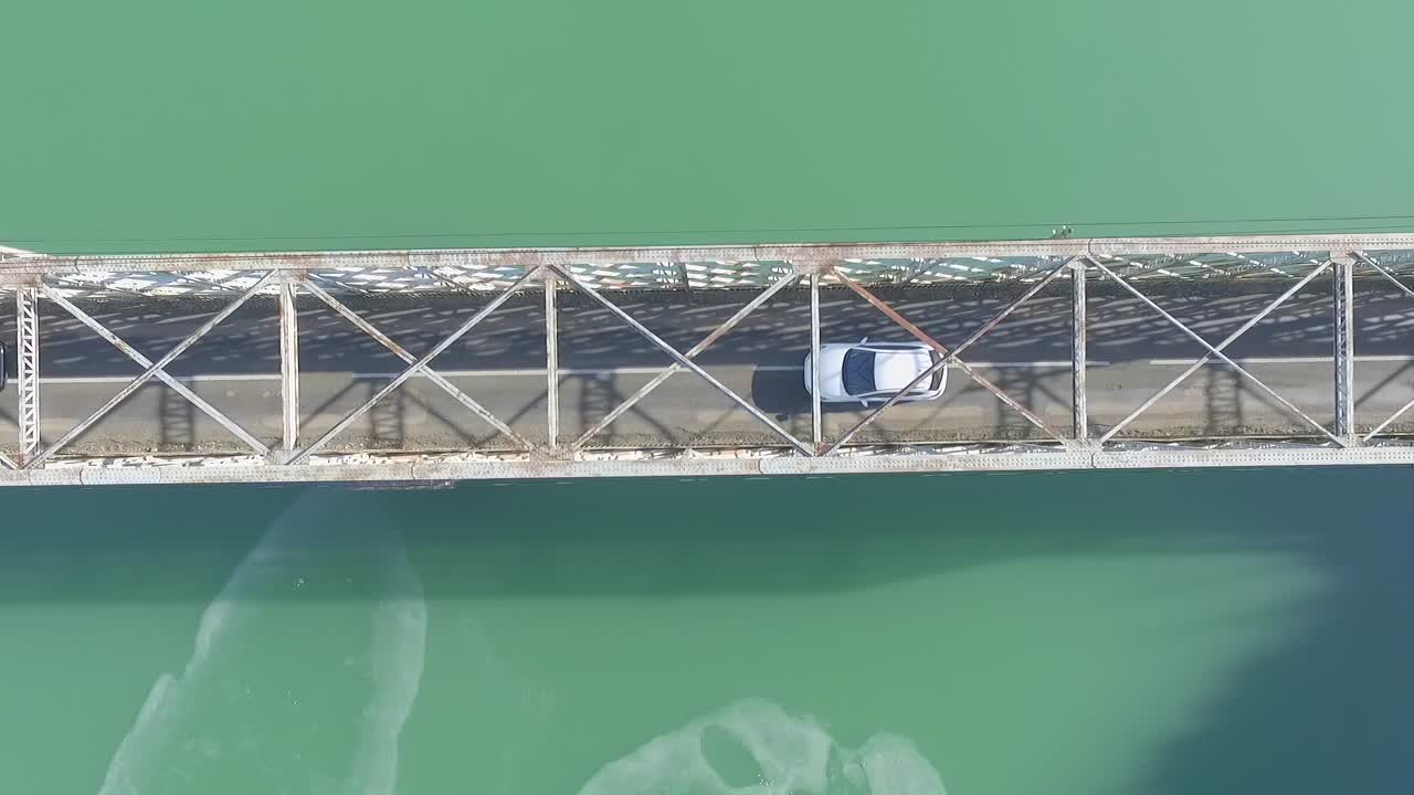 호수 위의 좁은 금속 볼티모어 유형 다리, 오버헤드 정적 공중을 통해 운전하는 두 대의 자동차