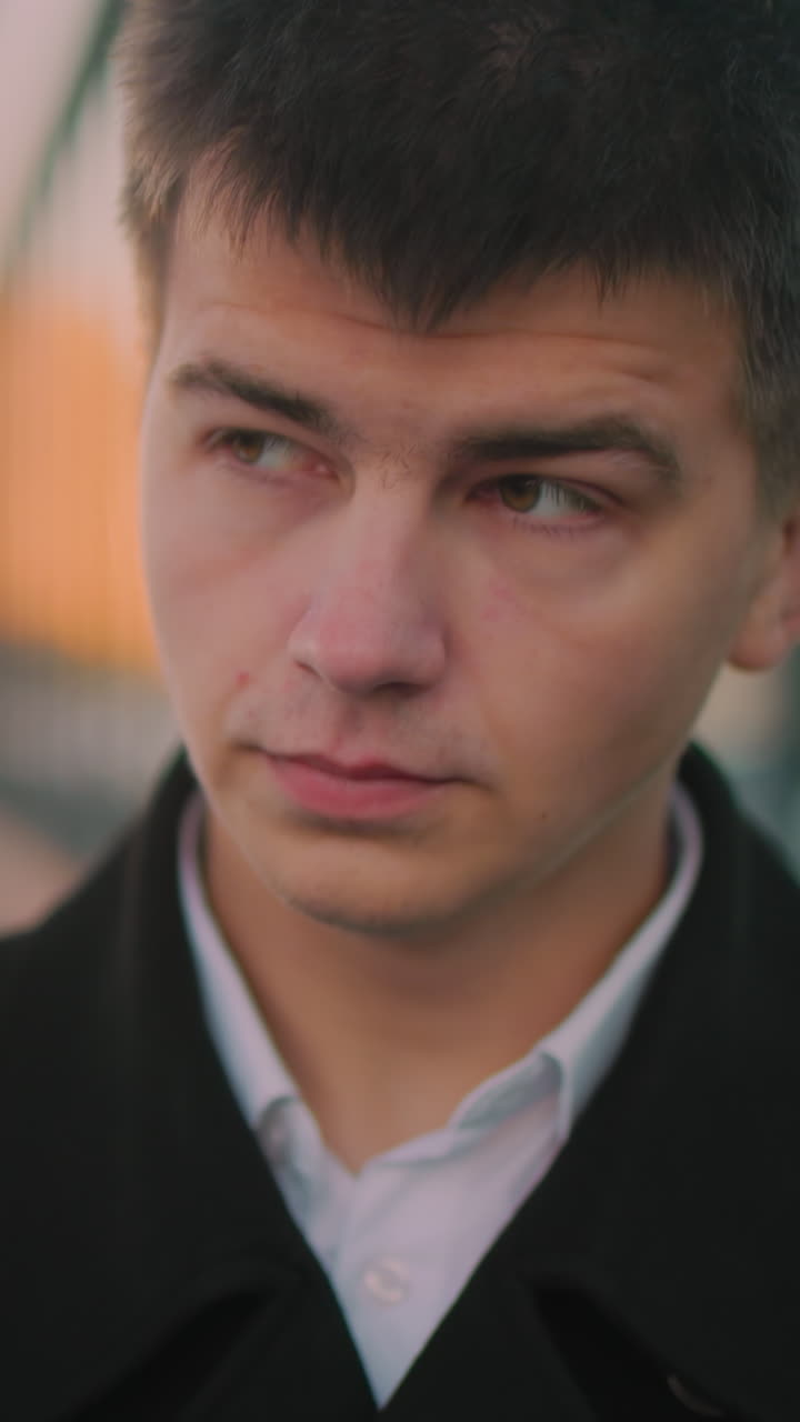 검은색 슈트를 입은 ceo가 야외에서 고, 다시 초점을 맞추기 전에 멀리 쳐다보고, 주차된 자동차와 불분명한 형상을 특징으로하는 흐릿한 배경으로, 전문적인 비즈니스 리더를 보여줍니다.