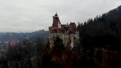 aerial, rising, drone shot, tilting towards the bran castle, home of the dracula legend, on a foggy, overcast, fall day, in transylvania, romania