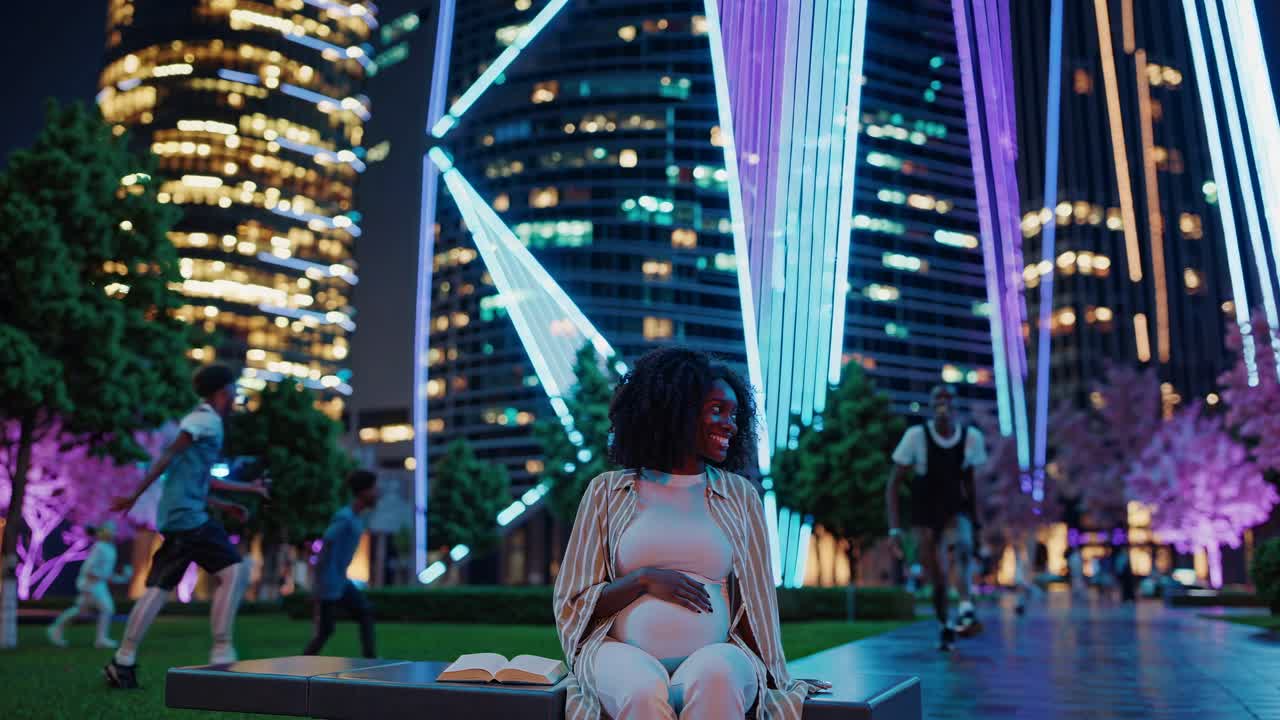 Pregnant woman reading a book in a city park at night