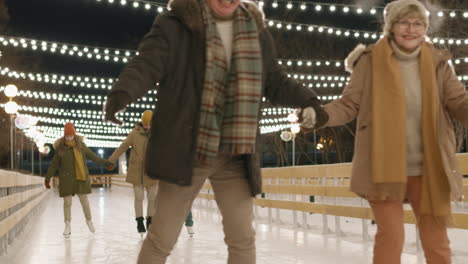 family and couple ice skating at night