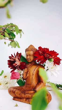 wooden buddha statue with flowers