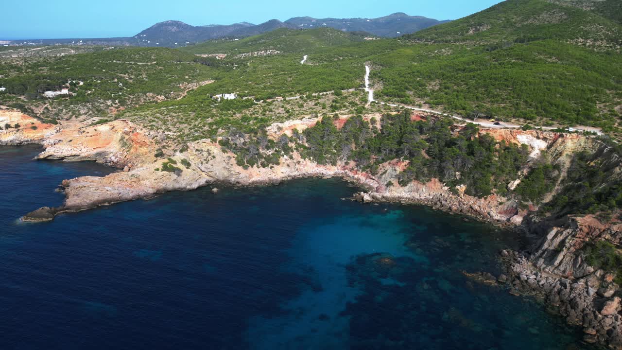 Ibiza coastline, showcasing the rugged cliffs and crystal clear turquoise waters of the mediterranean sea. Lovely aerial view flight static tripod hovering drone