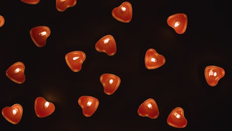 disparo de arriba de románticas velas rojas en forma de corazón iluminadas girando sobre un fondo negro 1