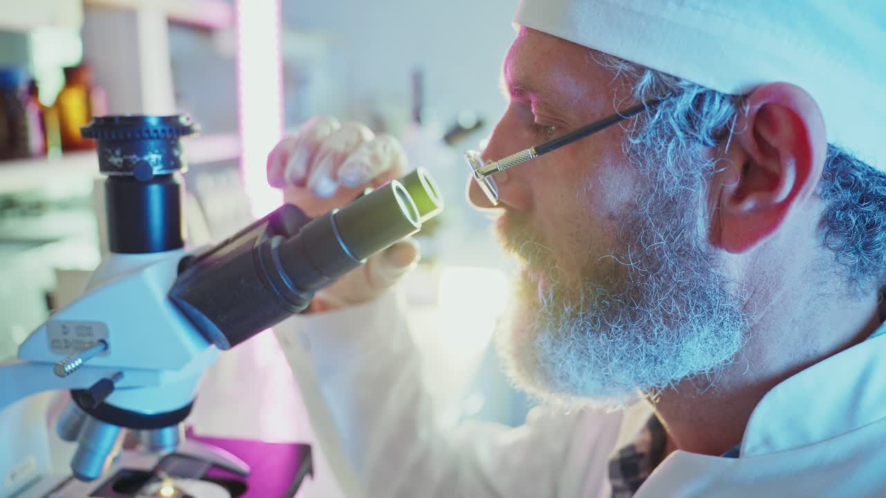 Ilmuwan Terfokus Bekerja dengan Mikroskop di Laboratorium Modern