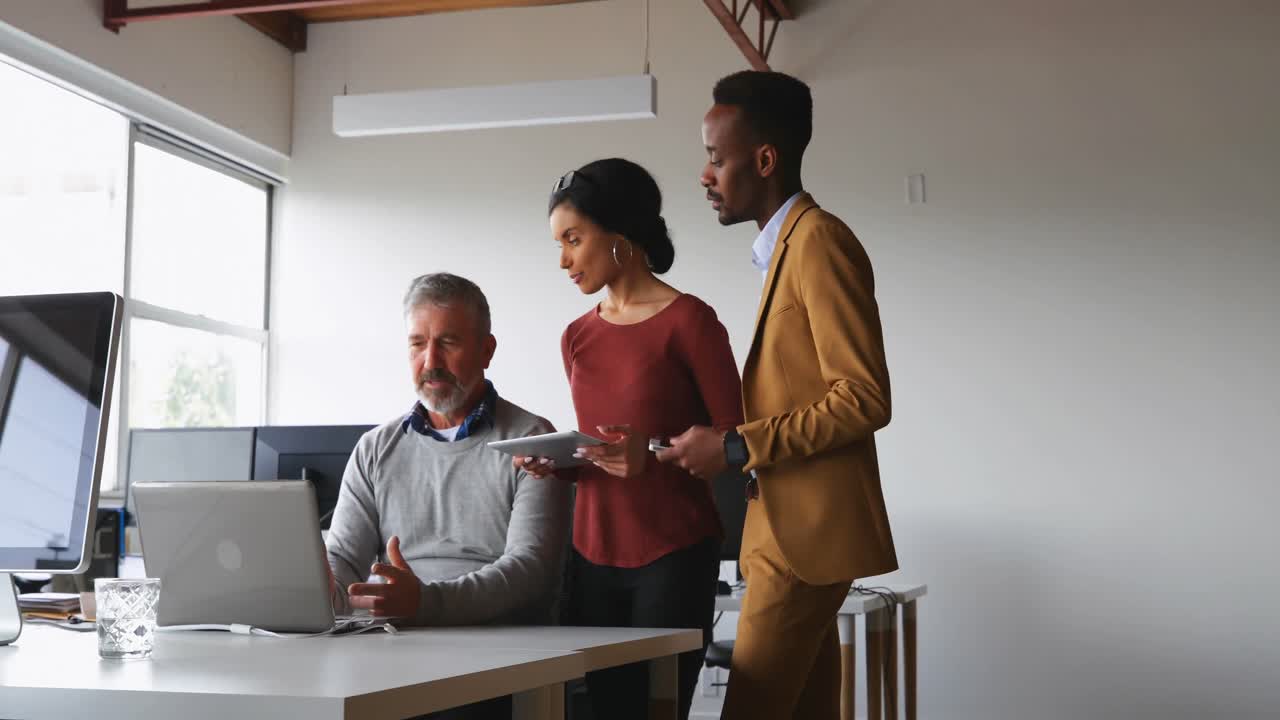 Executives discussing over laptop at desk 4k